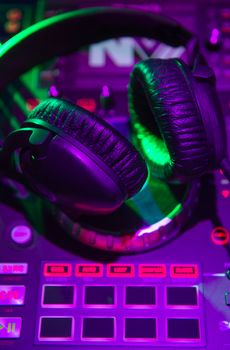 Dj mixer with headphones at a nightclub, music