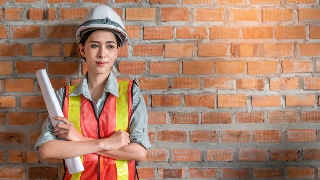 portrait of beautiful woman  engineer  in front of  brick wall with copy space