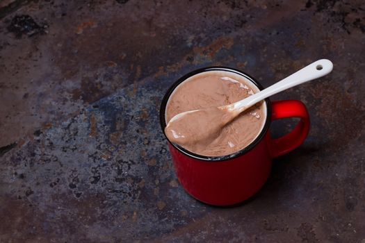 Hot chocolate in red mug on grunge background