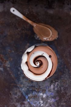 Wafer horn with chocolate ice cream and melted ice cream on grunge background