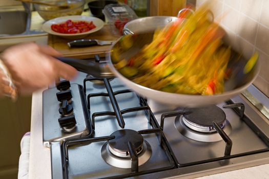 Whole farfalle pasta with zucchini, cherry tomatoes and red onion stir-fry in the pan