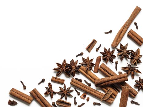 Winter spices background. Cinnamon, cloves and star anise with copy space. Isolated on white with clipping path. Top view or flat lay. Winter food background concept.