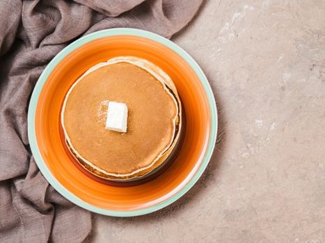 Top view of homemade pancakes. Stack of pancakes on brown concrete background.