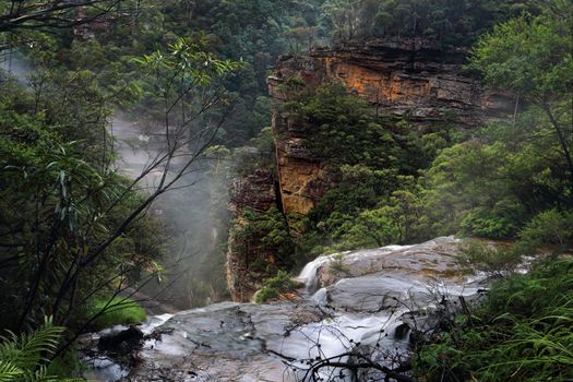 Water fed by the Jamison Creek  flows over the cliff edge at Wentworth Falls for a drop of around 187 metres to the bottom of the valley
