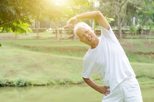 Portrait of healthy gray hair Asian old man stretching at outdoor park in morning.