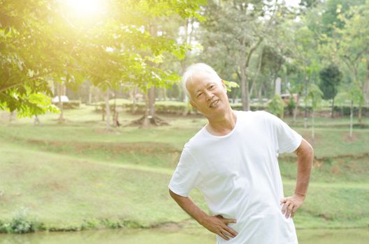 Portrait of healthy and active gray hair Asian old man stretching at outdoor park in morning.