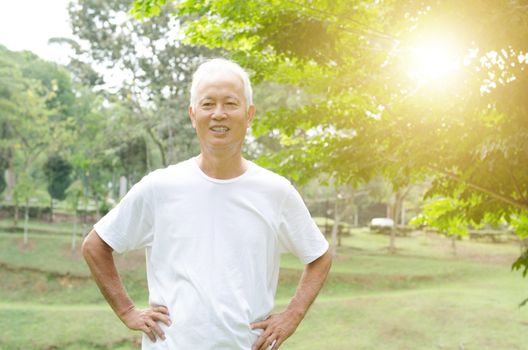 Portrait of healthy gray hair Asian old man smiling at outdoor park in morning.