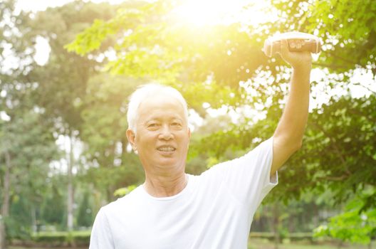 Portrait of sporty and healthy grey hair Asian old man exercising at outdoor park in morning.