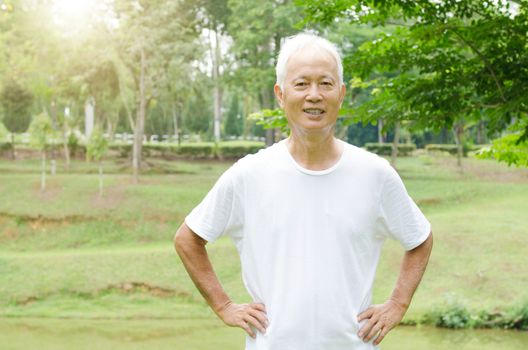 Portrait of happy gray hair Asian old man smiling at outdoor park in morning.
