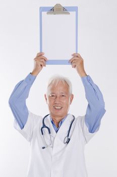 Portrait of old Asian medical doctor showing health report, standing isolated on white background.