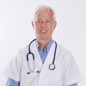 Portrait of confident Asian medical doctor smiling, standing isolated on white background.