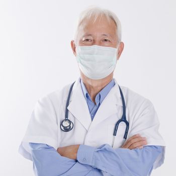 Portrait of Asian medical doctor in face mask, standing isolated on white background.
