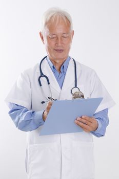Portrait of Asian male medical doctor writing health report, standing isolated on white background.