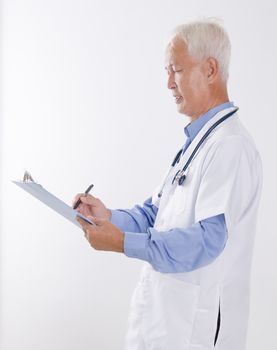 Portrait of Asian medical doctor writing health report, standing isolated on white background.
