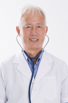 Portrait of old Asian medical doctor smiling, standing isolated on white background.