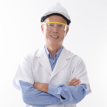 Portrait of old Asian senior engineer with hard helmet and uniform smiling, standing isolated on white background.
