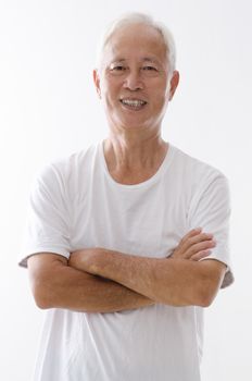 Portrait of old Asian man arms crossed standing isolated on white background.