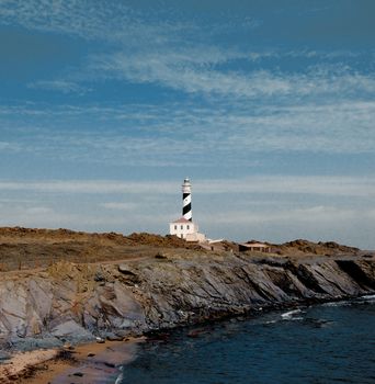 Lighthouse Faro de Favaritx against Dramatic Sky background. Menorca, Balearic Islands. 