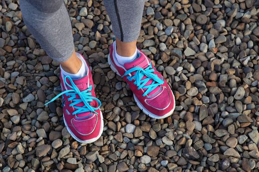 pink sports shoes of woman on gravel