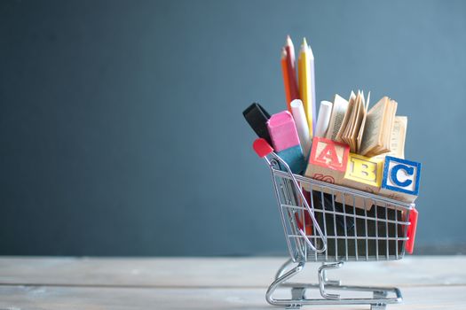Shopping cart filled with stationery against a chalkboard