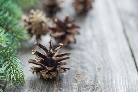 Christmas composition: pine cones and spruce branches on the background of old unpainted wooden boards. Christmas wallpaper