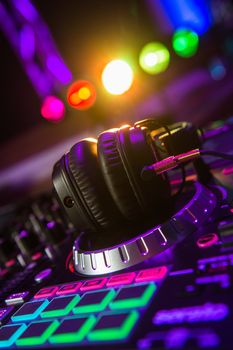 Dj mixer with headphones at a nightclub, music