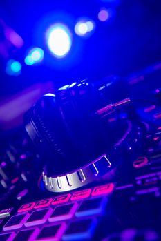 Dj mixer with headphones at a nightclub, music