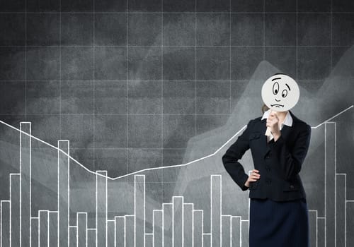 Businesswoman and graphs at background hiding her face behind mask