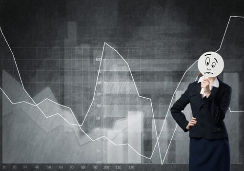Businesswoman and graphs at background hiding her face behind mask