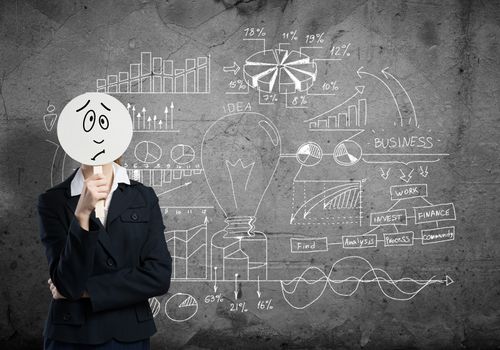 Businesswoman and graphs at background hiding her face behind mask