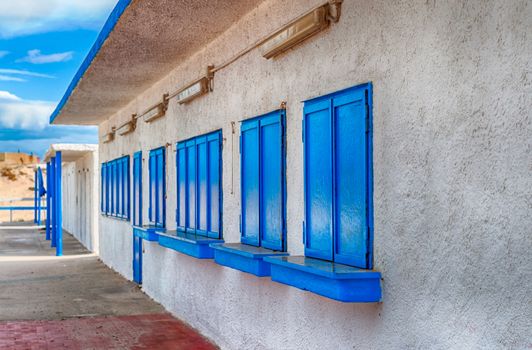 White and blue building on the beach in a cloudy day of autumn - Platamona - Sardinia - Italy