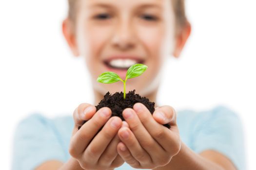 New life concept - handsome smiling child boy hand holding small green plant sprout leaf growth at dirt soil heap white isolated