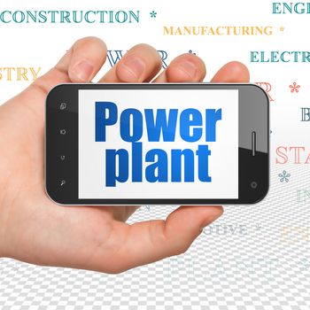 Manufacuring concept: Hand Holding Smartphone with  blue text Power Plant on display,  Tag Cloud background, 3D rendering