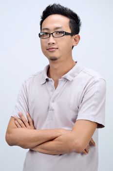 Portrait of confident Asian man arms crossed, standing isolated on plain background.