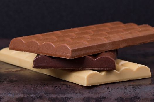 stack of different kind porous chocolate pieces on a dark background.