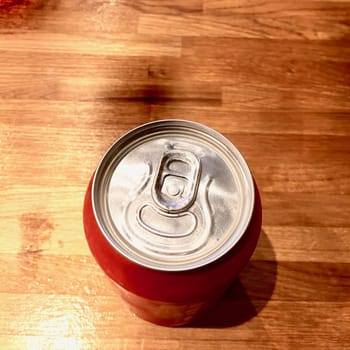 Small red can with drink on the wooden table. Drink concept.