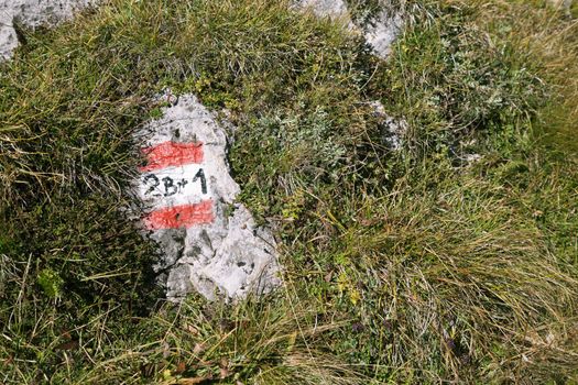 Trail marker for hikers on a mountain path on a sunny day