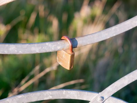an old locked metal padlock outside on rail; England; Essex