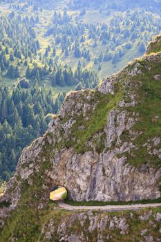 Tunnel in the rock along a trekking path, Italian alps