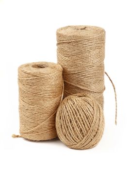 Group of three different coil bobbin of natural brown twine hessian burlap jute rope over white background, close up, high angle side view