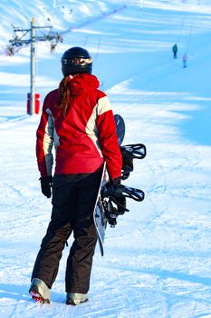 Woman snowboarder on the snow slopes on sunny winter day