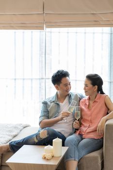 Young Couples celebrate together with wine  in bedroom of contemporary house for modern lifestyle concept