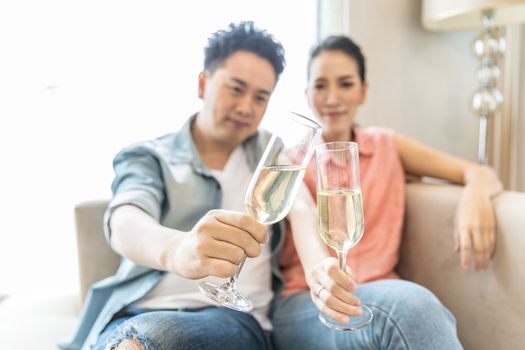 Young Couples celebrate together with wine  in bedroom of contemporary house for modern lifestyle concept (Focus at glasses)