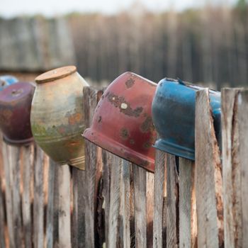 Old wooden boundary fence with nails on sunny day