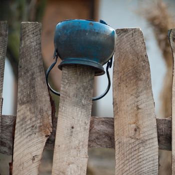 Old wooden boundary fence with nails on sunny day