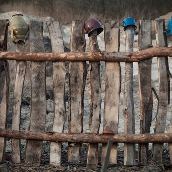 Old wooden boundary fence with nails on sunny day
