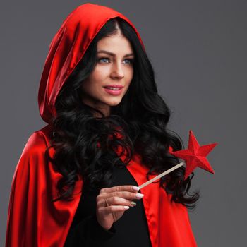 Woman with star shaped magic wand on black