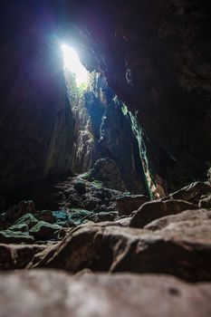 Inside view of limestone cave with light coming from upside, Thailand