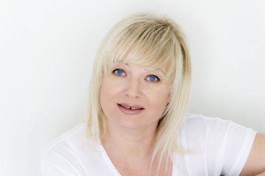 Horizontal portrait of blond woman with blue eyes in white