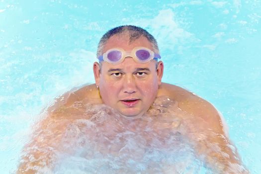 Portrait of big fat man in swimming pool water